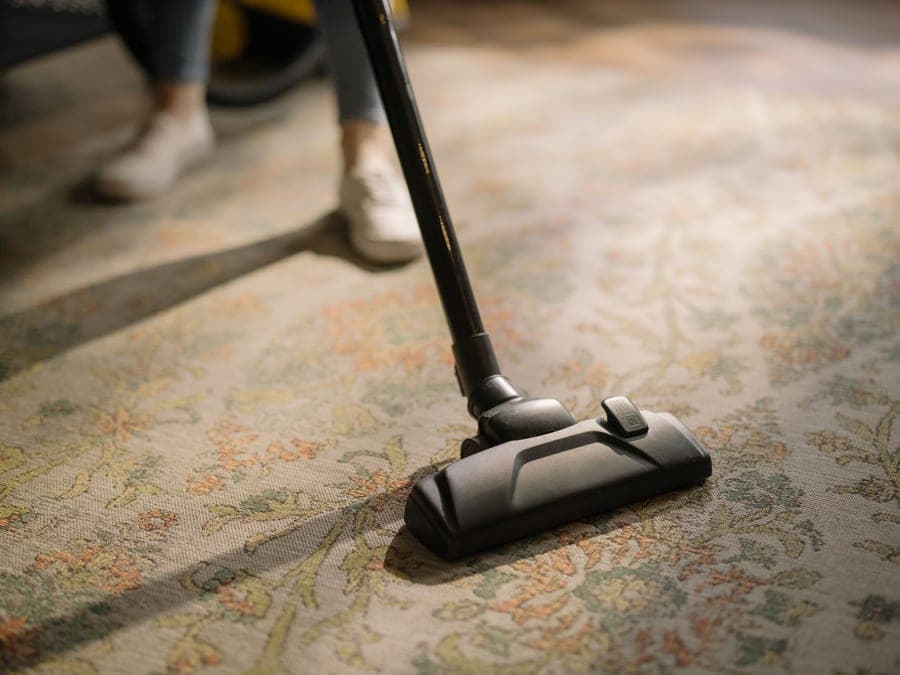 A carpet cleaning machine being used on a living room carpet